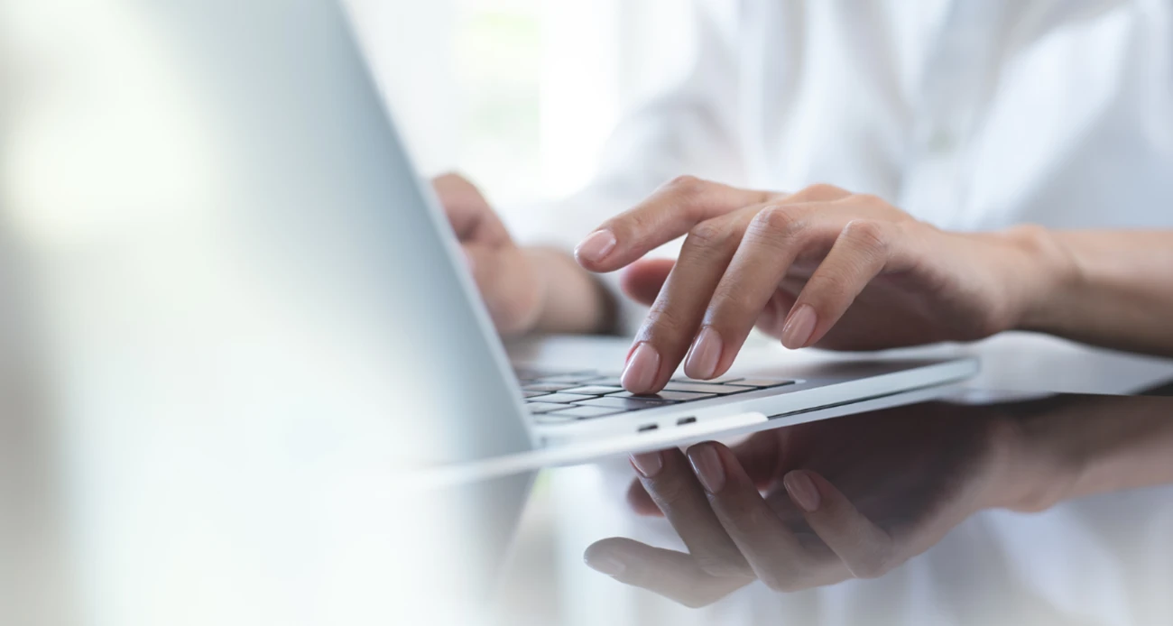 kobieta pisząca na klawiaturze laptopa